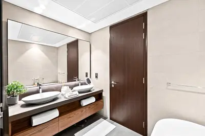 a bathroom with two sinks and a mirror at Luxury 1 Bedroom Apartment in Dubai Marina 5 Star in Dubai