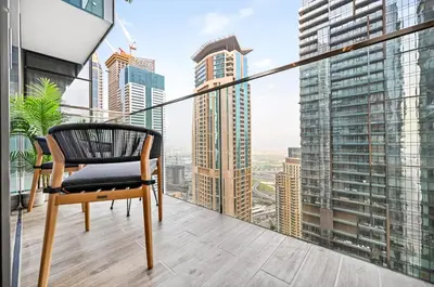 a chair on a balcony with a view of a city at Luxury 1 Bedroom Apartment in Dubai Marina 5 Star in Dubai