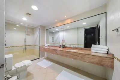 a bathroom with a sink and a shower and a mirror at Royal Oceanic Elegant 2BR with Marina View in Dubai