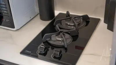 a black stove top on a counter next to a laptop at Luxurious Design Boutique Studio Hideaway JVC in Dubai