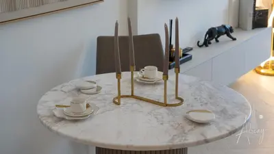 a marble table with cups and saucers on it at Luxurious Design Boutique Studio Hideaway JVC in Dubai