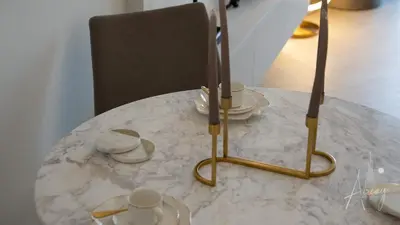 a table with a hat and cups and a chair at Luxurious Design Boutique Studio Hideaway JVC in Dubai