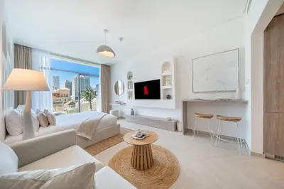 a white living room with a couch and a table at Luxurious Design Boutique Studio Hideaway JVC in Dubai
