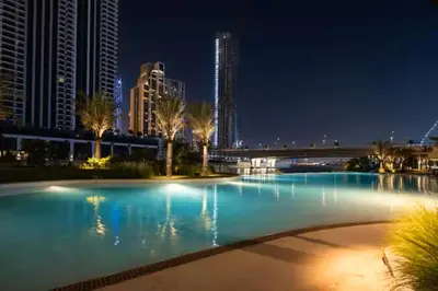 a large pool of water at night with tall buildings at Vogue Creek Beach Rosewater Waterfront Living close to Downtown, Burj Khalifa and Dubai mall, Two Bedroom Apartment with Balcony and Vibrant Community View, Private Manmade Beach, Access to all Amenities in Sabkhah