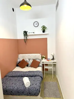 a small bedroom with a bed and a clock on the wall at Attractive Partition Room Tecom Barsha Heights in Dubai