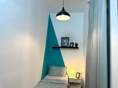 a bedroom with a bed and a green and white wall at delightful Partition Room Barsha Heights Tecom in Dubai
