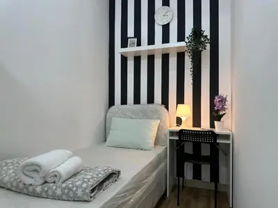 a small bedroom with a bed with towels on it at Nice Looking Partition Room Barsha Heights Tecom in Dubai