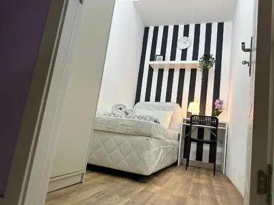 a small bedroom with a bed and a black and white wall at Nice Looking Partition Room Barsha Heights Tecom in Dubai