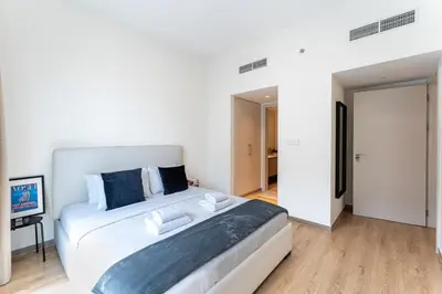 a white bedroom with a large bed and a television at DAYF-PAR Large 3 Bed with Full Skyline View in Dubai Hills in Dubai