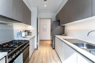 a kitchen with white cabinets and a sink and a stove at DAYF-PAR Large 3 Bed with Full Skyline View in Dubai Hills in Dubai