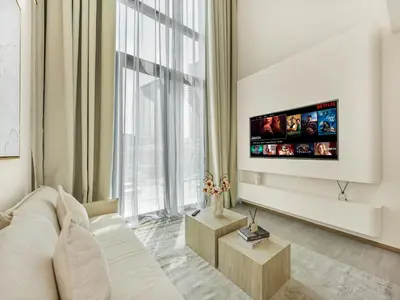 a living room with a white couch and a flat screen tv at Brand New Luxury Duplex in 5 Star JVC Development in Dubai