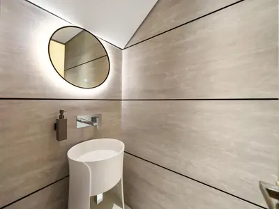 a bathroom with a mirror and a white sink at Brand New Luxury Duplex in 5 Star JVC Development in Dubai