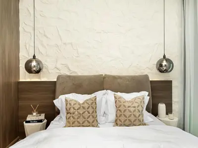 a bedroom with a white bed with two pillows at Brand New Luxury Duplex in 5 Star JVC Development in Dubai