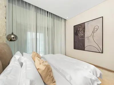 a bedroom with a white bed and a window at Brand New Luxury Duplex in 5 Star JVC Development in Dubai