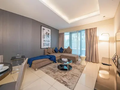 a living room with a couch and a table at Luxurious paramount 2BR with Pool,Gym, Sauna & Bar 10 mins to Burj Khalifa in Dubai