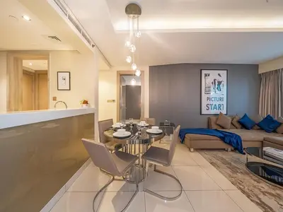 a living room with a table and a couch at Luxurious paramount 2BR with Pool,Gym, Sauna & Bar 10 mins to Burj Khalifa in Dubai