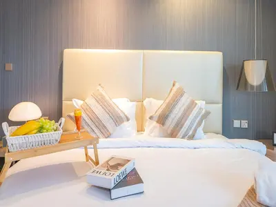 a hotel room with a bed and a table with a book at Luxurious paramount 2BR with Pool,Gym, Sauna & Bar 10 mins to Burj Khalifa in Dubai