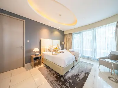 a bedroom with a large bed and a large window at Luxurious paramount 2BR with Pool,Gym, Sauna & Bar 10 mins to Burj Khalifa in Dubai