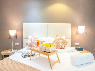 a bed with a bowl of fruit on a table at Luxurious paramount 2BR with Pool,Gym, Sauna & Bar 10 mins to Burj Khalifa in Dubai