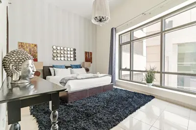 a living room with a bed and a large window at VayK - Chic 1BR with Marina View in Park Island in Dubai