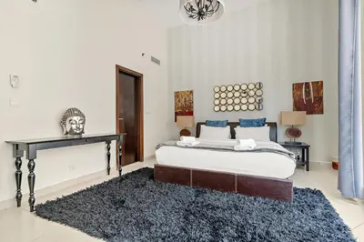 a bedroom with a bed and a black rug at VayK - Chic 1BR with Marina View in Park Island in Dubai