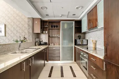 a kitchen with wooden cabinets and a sink at VayK - Chic 1BR with Marina View in Park Island in Dubai