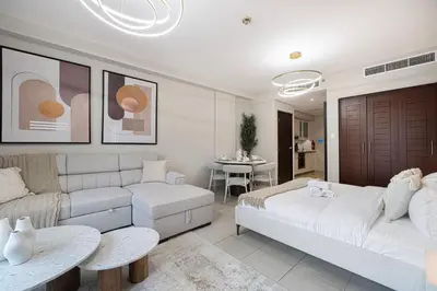 a living room with a bed and a couch at Chic Studio Apartment, Pool and Balcony, Steps to Burj Khalifa in Dubai