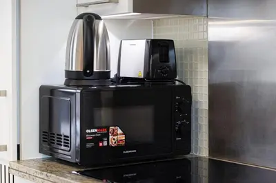 a microwave with a coffee maker on top of it at Chic Studio Apartment, Pool and Balcony, Steps to Burj Khalifa in Dubai
