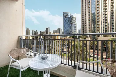 a balcony with a table and chairs and a city at Chic Studio Apartment, Pool and Balcony, Steps to Burj Khalifa in Dubai