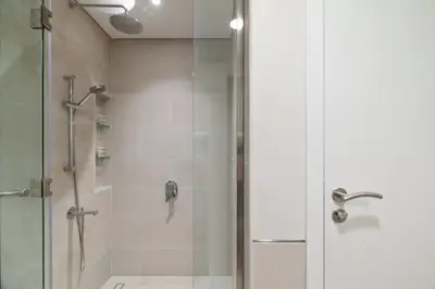 a bathroom with a shower with a glass door at Spacious 1BD, City View, Pool & Beach access in Dubai