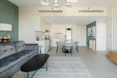 a living room with a couch and a table at Spacious 1BD, City View, Pool & Beach access in Dubai