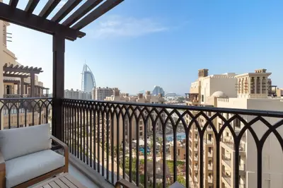 a balcony with a chair and a view of the city at Spacious 1BD, City View, Pool & Beach access in Dubai