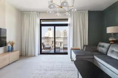 a living room with a couch and a large window at Spacious 1BD, City View, Pool & Beach access in Dubai