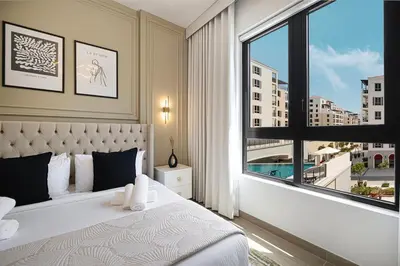 a bedroom with a bed and a large window at Stylish Apartment - Private Beach - Port de La Mer in Dubai
