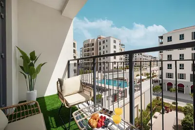 a balcony with a chair and a table with food on it at Stylish Apartment - Private Beach - Port de La Mer in Dubai