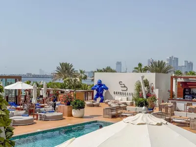 a resort with a pool and tables and chairs at Jumeirah Beach Residences Private Beach & Sea View in Dubai