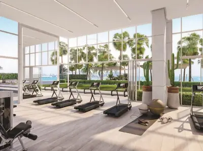 a gym with a lot of exercise equipment and palm trees at Jumeirah Beach Residences Private Beach & Sea View in Dubai
