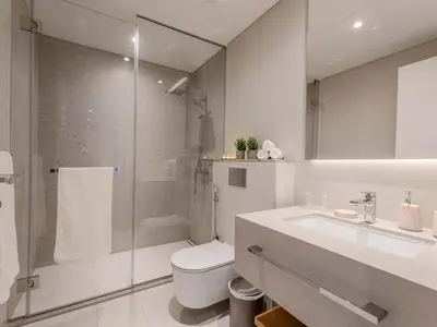 a bathroom with a shower and a toilet and a sink at Jumeirah Beach Residences Private Beach & Sea View in Dubai