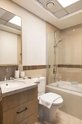 a bathroom with a toilet and a sink and a tub at The Burj View Suite Luxury 1BR Full Burj Views in Dubai