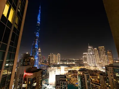 a city skyline at night with the spire lit up at The Burj View Suite Luxury 1BR Full Burj Views in Dubai