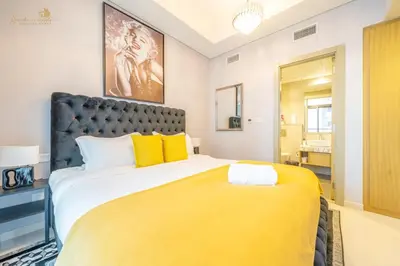 a bedroom with a large bed with yellow pillows at Serene Canal View 2Bhk 6 pax in Dubai