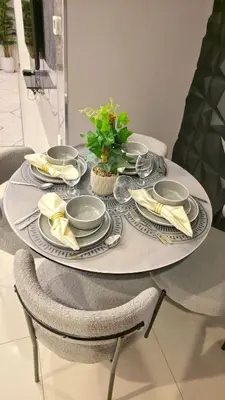 a table with plates and napkins and a plant on it at Serene Canal View 2Bhk 6 pax in Dubai