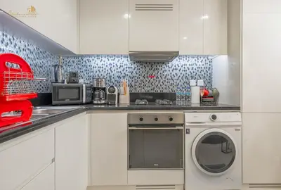 a kitchen with a dishwasher and a washing machine at Serene Canal View 2Bhk 6 pax in Dubai