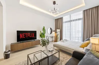 a living room with a couch and a tv at Elite Escape - Getaway in Azizi Riviera 13 in Dubai
