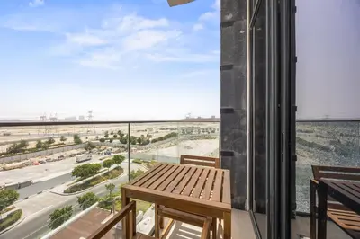 a balcony with a table and a view of the desert at Elite Escape - Getaway in Azizi Riviera 13 in Dubai