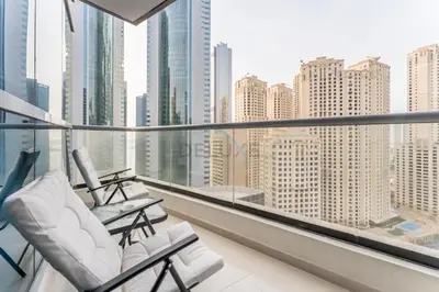 a balcony with white chairs and a view of the city at Short Walk to Marina Mall, Marina Walk and JBR Beach, Stunning Marina Views - Bay Central 2, Dubai Marina by Deluxe Holiday Homes in Dubai