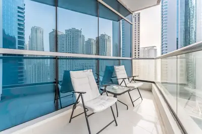 a balcony with white chairs and a view of the city at Short Walk to Marina Mall, Marina Walk and JBR Beach, Stunning Marina Views - Bay Central 2, Dubai Marina by Deluxe Holiday Homes in Dubai