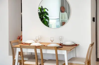 a dining room table with a mirror on the wall at Vida Yacht Club Marina 2BDR Sky Suite in Dubai