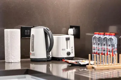 a kitchen counter with a coffee maker and water bottles at Vida Yacht Club Marina 2BDR Sky Suite in Dubai