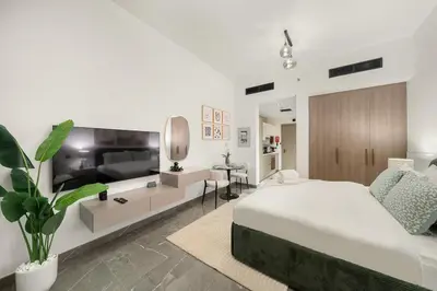 a bedroom with a bed and a living room at Dubai Arjan Studio - Near Miracle Garden, Hills Mall & Attractions in Dubai